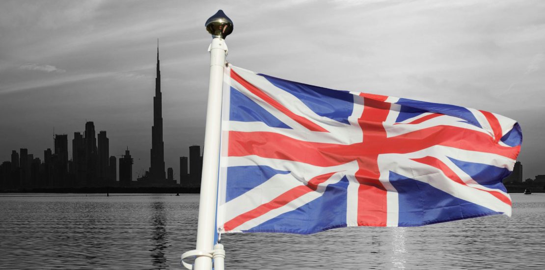 uk flag over dubai skyline